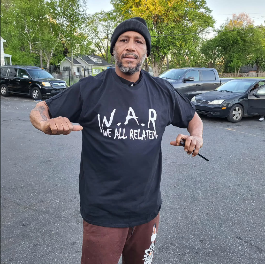 Man wearing a black W.A.R. — We All Related t-shirt