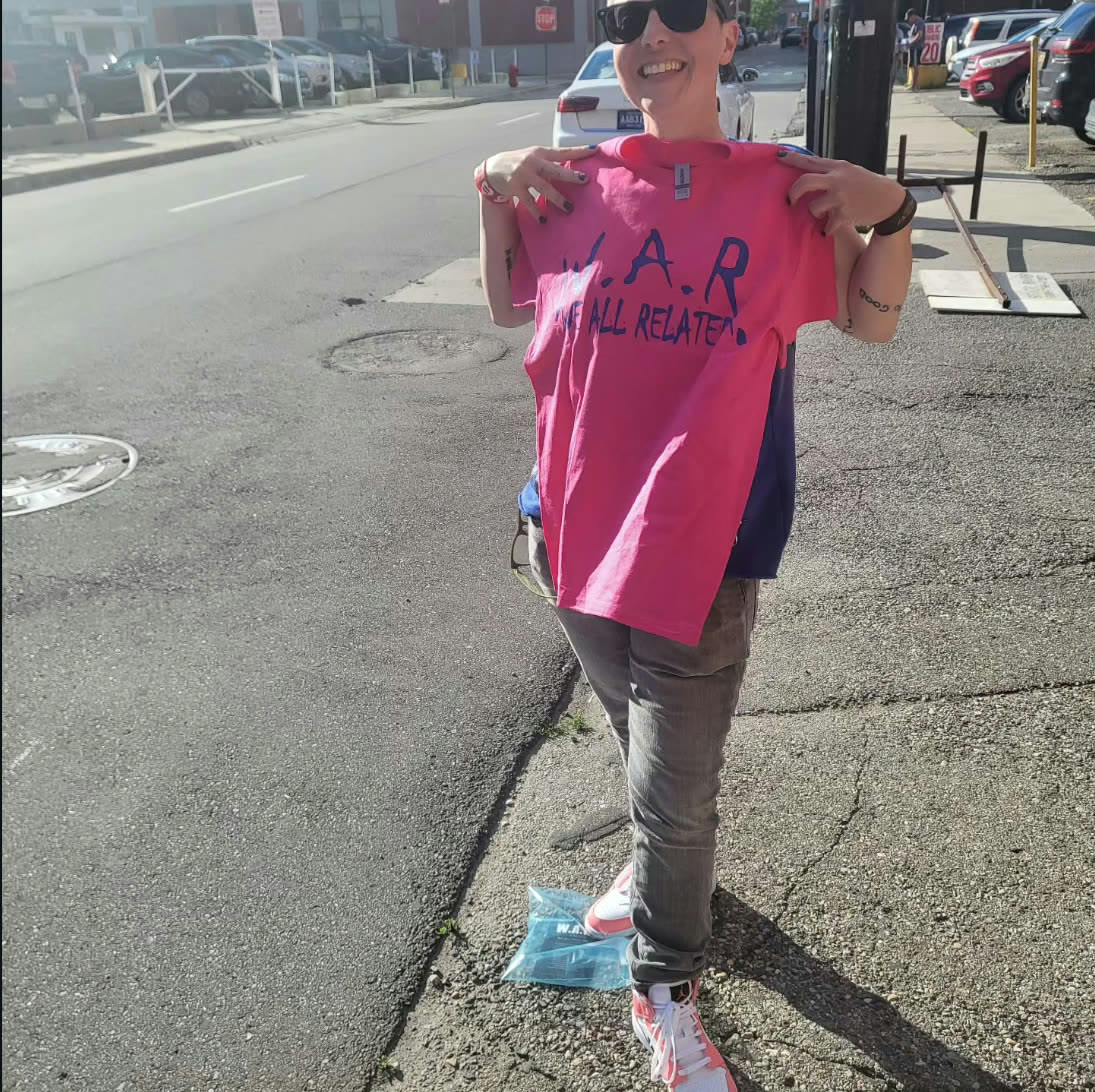 Woman wearing a hot pink W.A.R. — We All Related t-shirt